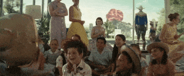 a group of people are gathered in a room with a globe in the foreground