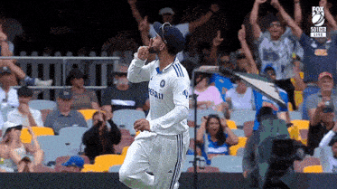 a cricket player is celebrating a wicket in front of a crowd of fans .