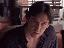 a man is sitting in a chair in a diner and looking at the camera .