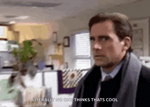 a man in a suit and tie is standing in an office and says `` literally no one thinks thats cool '' .