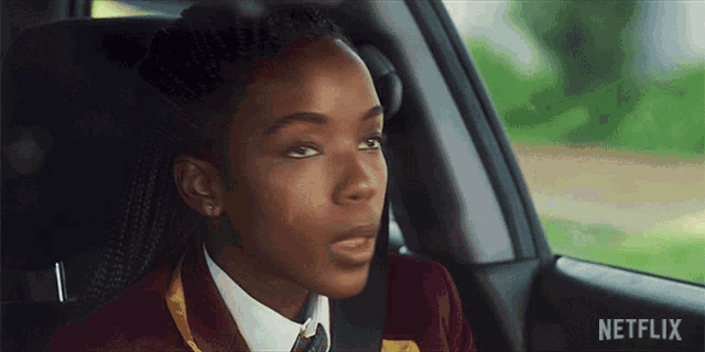 a girl is sitting in the back seat of a car with netflix written on the bottom