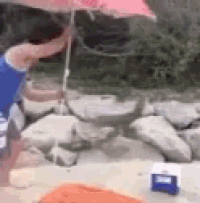 a person is holding an umbrella over their head on the beach .