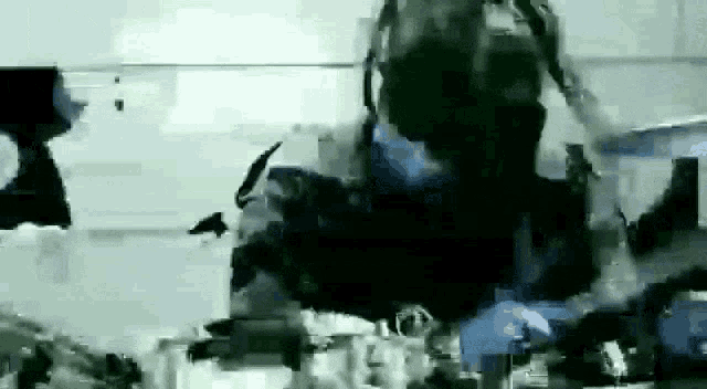 a blurry picture of a person standing in a room with a lot of objects .