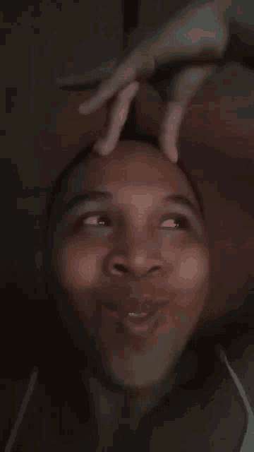 a close up of a person making a funny face with their hands on their head