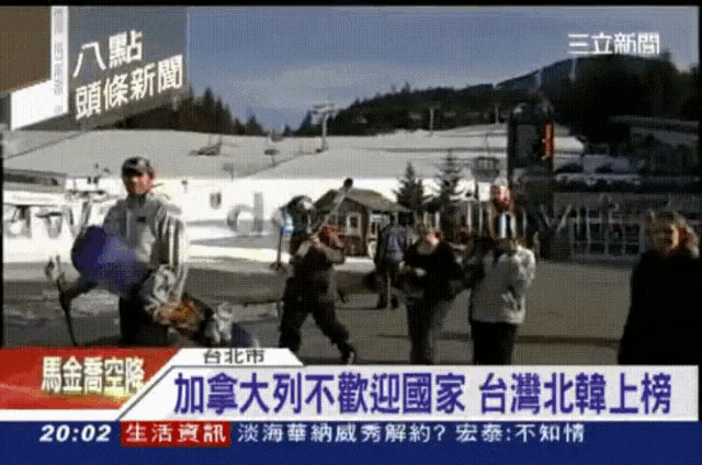 a tv screen shows a group of people standing in front of a snowy mountain