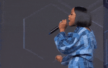 a woman is singing into a microphone and the word might is on the bottom