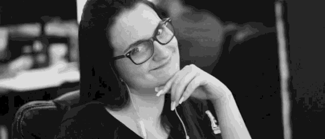 a black and white photo of a woman wearing glasses and headphones