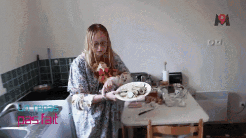 a woman sitting at a table with a plate of food in front of a sign that says 191