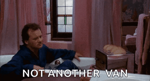 a man is sitting in a bathtub with the words not another van below him .