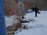 a person is standing in the snow near a soccer net