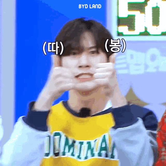 a boy wearing a yellow shirt that says jomina makes a face