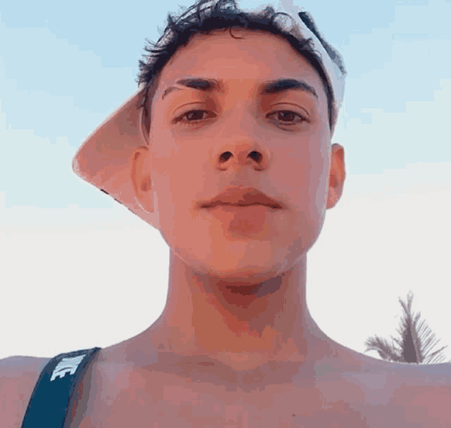 a shirtless young man wearing a nike strap around his neck