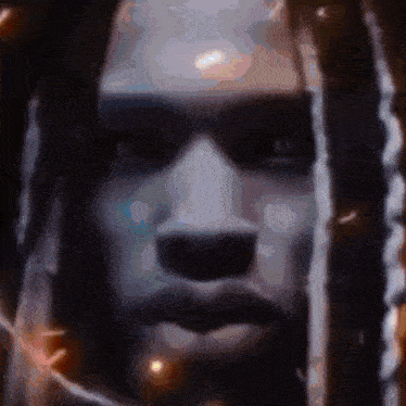 a close up of a man 's face with dreadlocks and sunglasses on