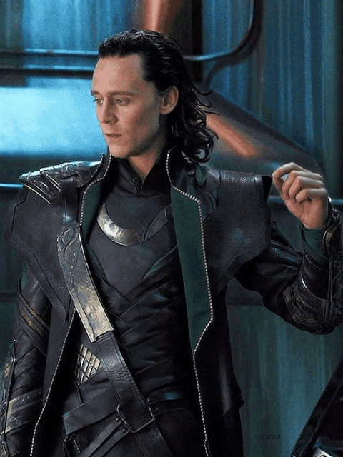 a man with long hair is wearing a black jacket with a green collar