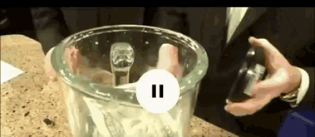 a man in a suit is using a blender with a pause button