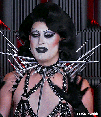 a drag queen is wearing a choker with spikes on it