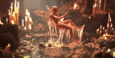 a naked woman is laying on a rock in a cave surrounded by candles .