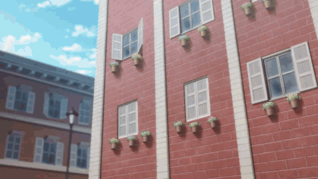 a brick building with a lot of windows and potted plants on the side