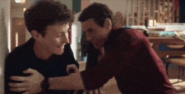 two young men are hugging each other and smiling at each other