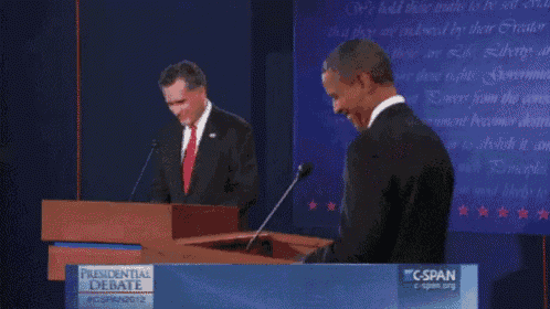 two men standing at a podium with a banner that says presidential debate on it