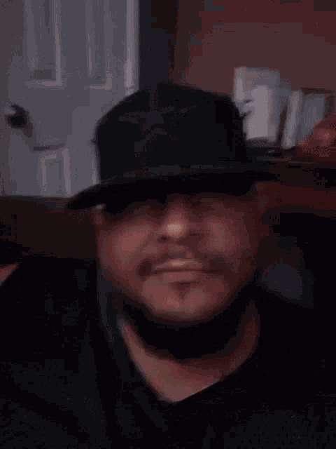 a man wearing a black hat with a star on it is making a peace sign