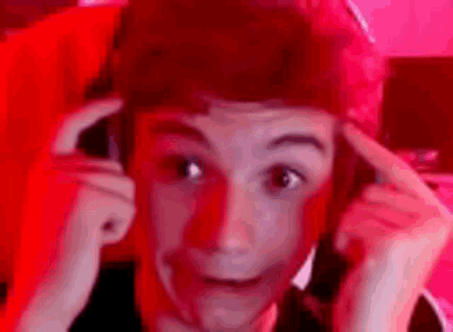 a young boy wearing headphones is making a funny face while sitting in a red chair .