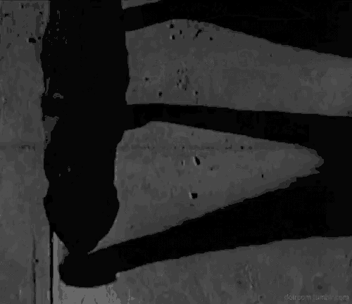 a black and white photo of a person 's shadow on the sidewalk .