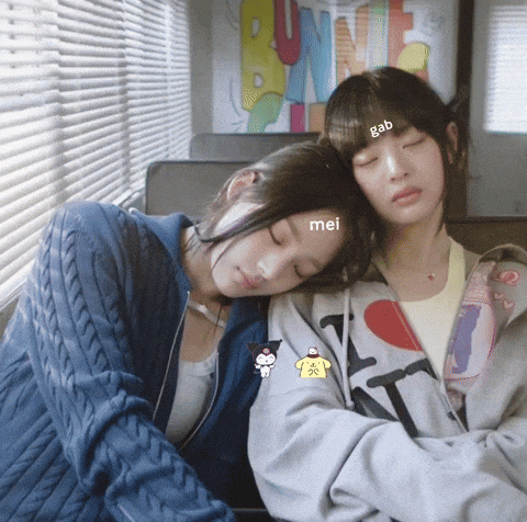 two girls are sleeping and one has a sticker on her head that says gab mei