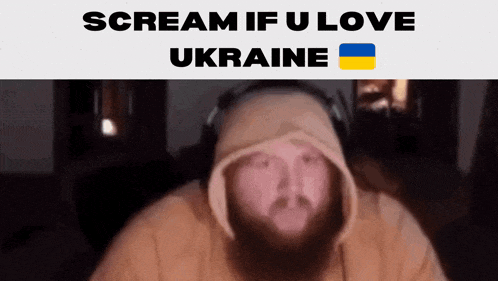 a man with a beard wearing headphones and a hoodie with the words scream if u love ukraine