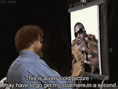 a man with a beard is painting a picture of a man with sunglasses on