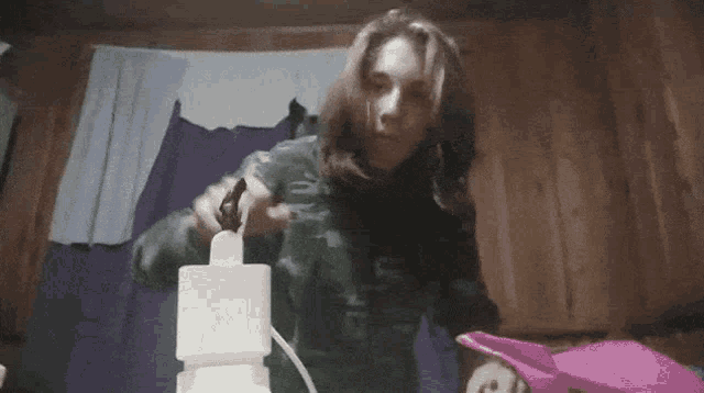 a woman with long hair is plugging a cord into a white box