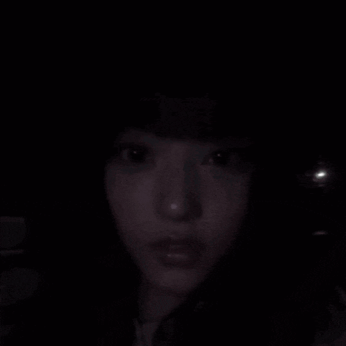 a close up of a woman 's face in the dark with the words `` hi '' above her .
