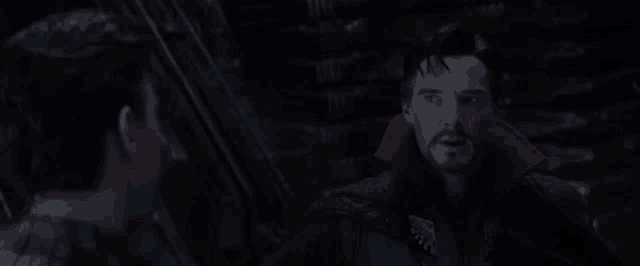 doctor strange and spider-man are talking to each other in a dark room in a movie .