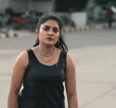 a woman wearing a black tank top and a silver chain necklace