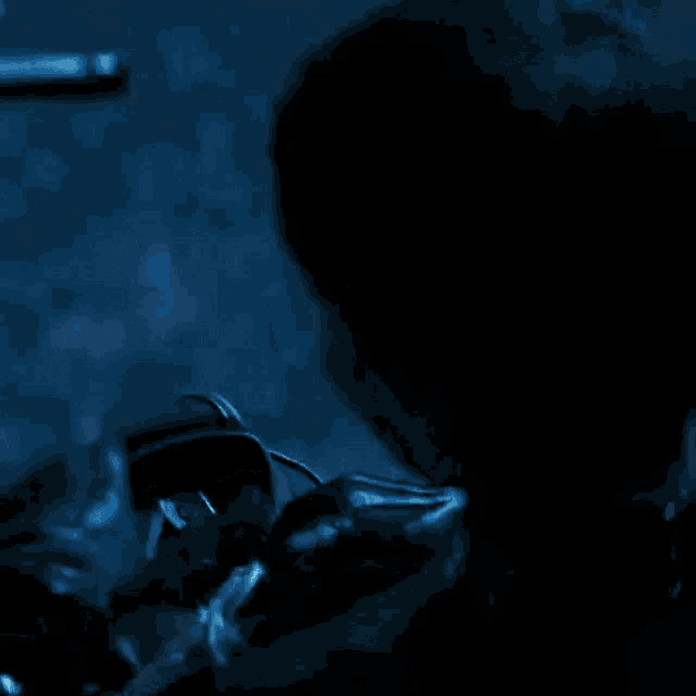 a person is standing in the dark with a bag on their back