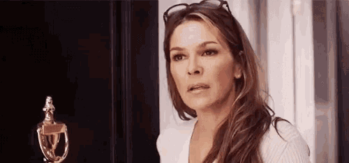 a woman is standing in front of a door and looking at the camera .
