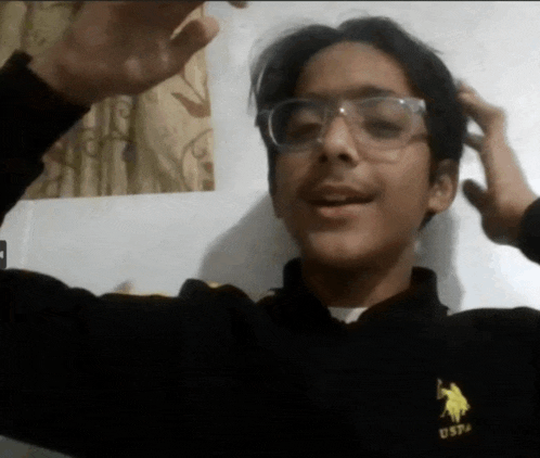a young man wearing glasses and a uspa shirt