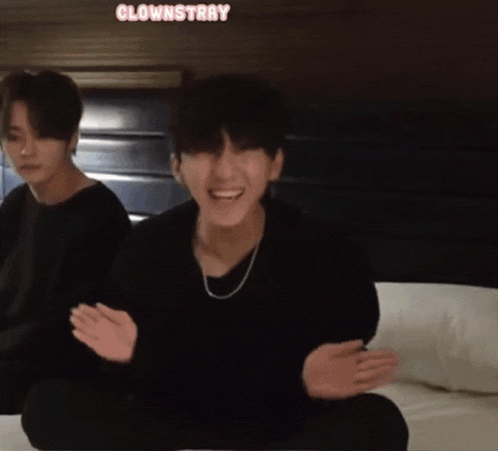 two boys are sitting on a bed with the word clownstray written on the bottom