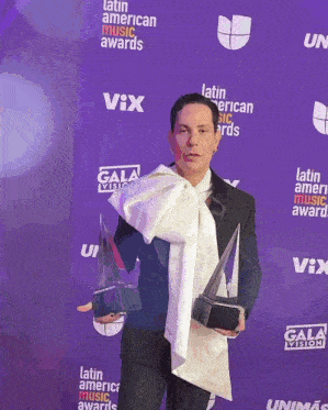 a man holding a trophy at the latin american music awards
