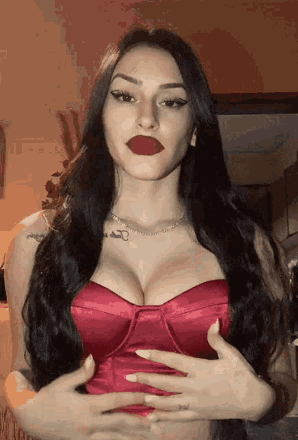 a woman wearing a red top has a tattoo on her chest that says ' a '