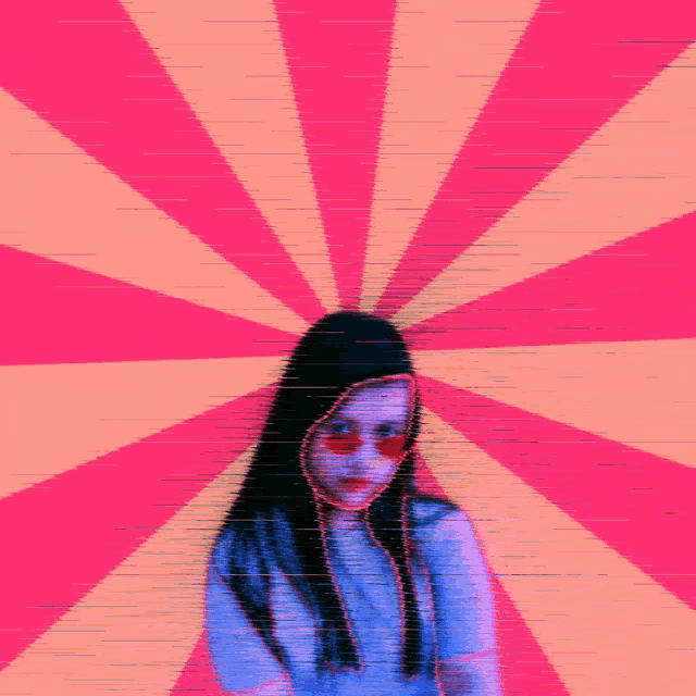a woman wearing sunglasses and a hood is standing in front of a pink and orange striped background