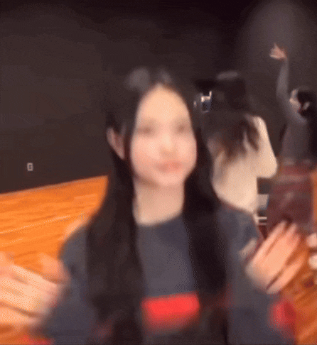 a blurry picture of a woman taking a picture with her phone