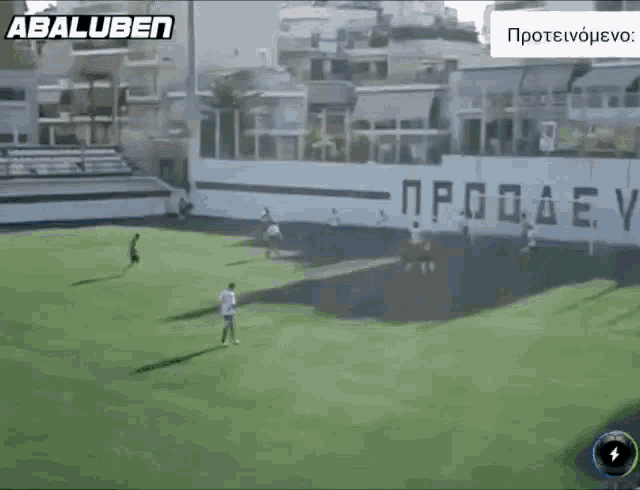 a soccer game is being played in front of a wall that says abaluben on it