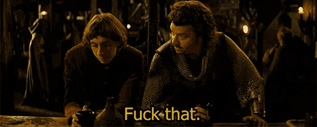 two men are sitting at a table and one of them is drinking from a pitcher with the words " fuck that " above him
