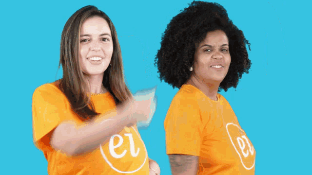two women wearing orange shirts with the letters er on them