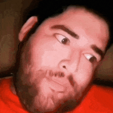 a man with a beard is making a funny face .