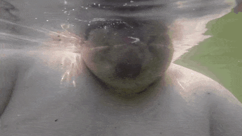 a close up of a person 's face underwater with bubbles coming out of it .