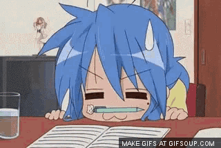 a girl with blue hair is sitting at a desk with a pencil in her mouth