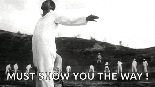 a man is standing in front of a group of people with his arms outstretched .