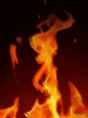 a person is standing in the middle of a fire with sparks coming out of it